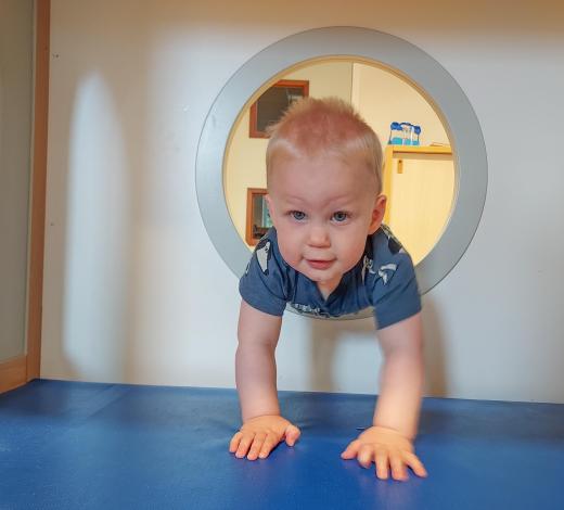 Kind kruipt door speeltoestel